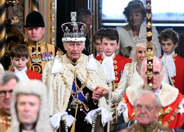 Britain's King Charles III, wearing the Imperial State Crown and the Robe of State, and Britain's Queen Camilla, wearing the George IV State Diadem, process through the Royal Gallery during the State Opening of Parliament at the Houses of Parliament, in London, on November 7, 2023. (Photo by JUSTIN TALLIS / POOL / AFP) (Photo by JUSTIN TALLIS/POOL/AFP via Getty Images)