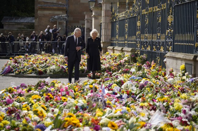 PA REVIEW OF THE YEAR 2022 File photo dated 13/09/22 - King Charles III and the Queen Consort view floral tributes left outside Hillsborough Castle, Co Down, following the death Queen Elizabeth II on Thursday. The King and Queen are visiting the four home nations of the UK in the run-up to the state funeral for Queen Elizabeth II. Issue date: Tuesday December 20, 2022. PA Photo. Photo credit should read: Niall Carson/PA Wire