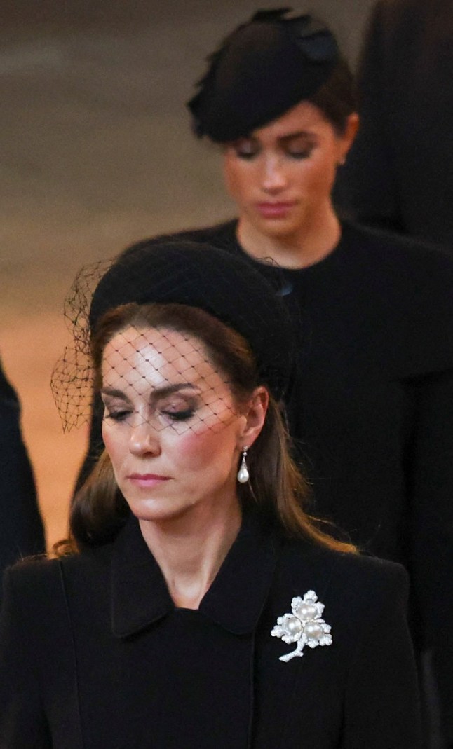 Britain's Catherine (L), Princess of Wales and Meghan (R), Duchess of Sussex, walk as the coffin of Queen Elizabeth II arrives at the Palace of Westminster, following a procession from Buckingham Palace, in London on September 14, 2022. - Queen Elizabeth II will lie in state in Westminster Hall inside the Palace of Westminster, from Wednesday until a few hours before her funeral on Monday, with huge queues expected to file past her coffin to pay their respects. (Photo by PHIL NOBLE / POOL / AFP) (Photo by PHIL NOBLE/POOL/AFP via Getty Images)
