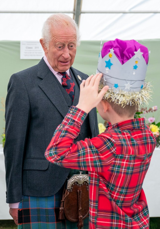 Oliver Keith, 8, from Portlethen, shows King Charles III a paper crown he made at the Royal Horticultural Society of Aberdeen Flower Show at Duthie Park, Aberdeen. Picture date: Saturday August 31, 2024. PA Photo. See PA story ROYAL King. Photo credit should read: Jane Barlow/PA Wire