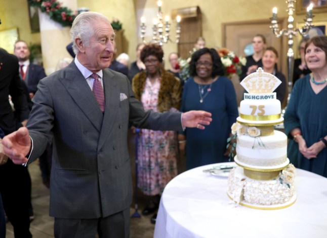 King Charles III next to a birthday cake during his 75th birthday party at Highgrove Gardens in Tetbury on the eve of his birthday, with community champions who are also celebrating turning 75 in 2023. Picture date: Monday November 13, 2023. PA Photo. See PA story ROYAL King. Photo credit should read: Chris Jackson/PA Wire