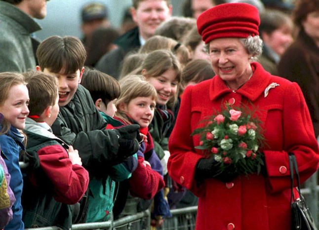 BELFAST, UNITED KINGDOM:Excited children watch HRH Elizabeth II during the opening ceremony for the Lagan Bridge in Belfast, Northern Ireland, 09 March. This is the first visit by the queen since the IRA ceasefire was announced six months ago. (COLOR KEY: Queen in red). AFP PHOTO (Photo credit should read STR/AFP via Getty Images)