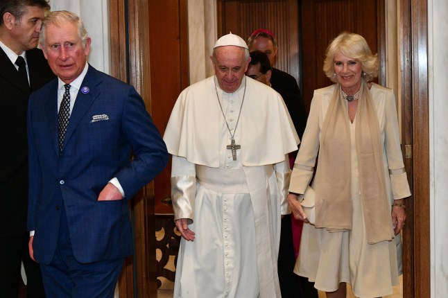 Pope Francis (C) welcomes Britain's Prince Charles and his wife Camilla, Duchess of Cornwall, as they arrive for a private audience on April 4, 2017 at the Vatican. (Photo by Vincenzo PINTO / POOL / AFP) (Photo by VINCENZO PINTO/POOL/AFP via Getty Images)